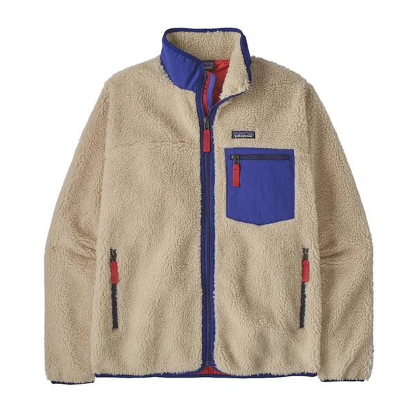 A Patagonia fleece jacket in beige with royal blue and red accents, featuring a stand-up collar, a chest pocket, and zippered hand pockets, shown against a plain white background.