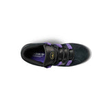 A top-down view of a black Adidas sneaker with purple straps and a purple interior, featuring a gold circular logo on the tongue, set against a plain white background.