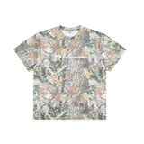 A short-sleeve crewneck t-shirt featuring an all-over camouflage pattern with tree bark, leaves, and pinecones in muted green, brown, beige, and gray tones. A semi-transparent white graphic reading 'FTP