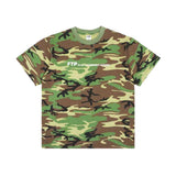 A short-sleeve crewneck t-shirt in a classic green, brown, and beige camouflage pattern, featuring the white text 'FTP is not a skateboard company' across the chest.