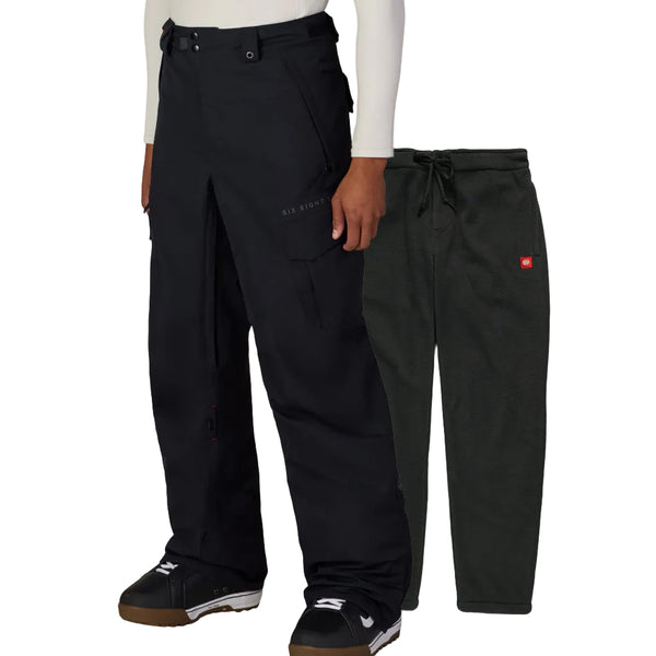 A model wears black cargo-style snow pants in the foreground, with a second pair of dar drawstring pants displayed behind them against a plain white background.