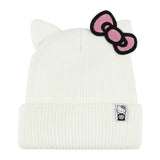 An off-white ribbed knit beanie hat featuring cat ears on top and a pink bow patch with black trim on the side, shown against a solid white background.