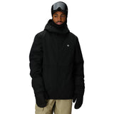 Person wearing a black jacket, goggles, and gloves on a white background