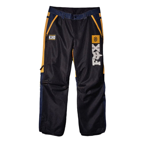 Black technical riding pants with navy blue waistband and side panels, yellow side stripe accents, a vertical white 'X-RAID' logo on the right leg, and a small white patch on the left thigh, displayed flat against a dark background.