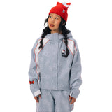 A model wearing a light blue Hello Kitty zip-up jacket and matching pants, styled with a red cat-ear beanie