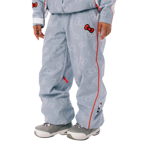 A person wearing a light blue Hello Kitty snow pants with a repeating Hello Kitty bow pattern, red piping, and red bow accents