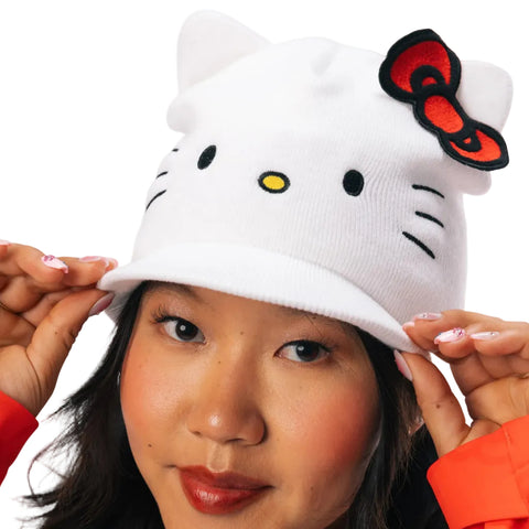 A white knit Hello Kitty beanie hat with a red bow