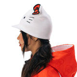 A woman in profile wearing a white Hello Kitty beanie with a red bow 