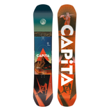 Two views of a CAPiTA snowboard shown side by side on a plain white background: the base from the front and the base from the back. The front view features a dark teal-to-orange scenic graphic with a moon and mountain, and the CAPiTA logo near the bottom.
