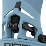Close-up of a snowboard binding with a light blue shell and black mechanical hardware, showing the release lever and adjustment screws.