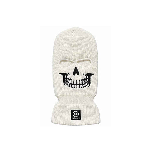 An off-white knit balaclava mask featuring a black embroidered skull face design and a small black square brand patch on the cuff, set against a plain white background.